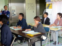 医療に関する講義を受ける学生たちが、真剣な表情で話を聞いている教室の様子。