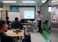 福島県立医科大学の教室で、講師がプレゼンテーションを行い、受講者が聴講している様子。