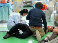 医療現場での救助活動の様子。患者に対して応急処置を行う医療スタッフとサポートする人々。