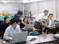 福島県立医科大学の教室で、複数の人がパソコンを使いながら作業している様子。