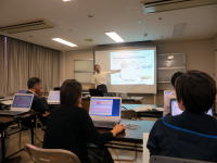 医療に関する講義を受ける学生たちと、プレゼンテーションを行う講師の様子。