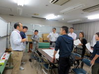 福島県立医科大学の会議室で、複数の人々が集まり話し合いをしている様子。