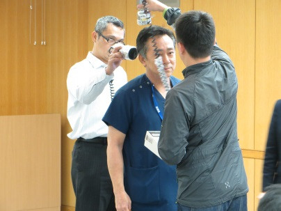 室内で放射線測定を行う研究者たちが、被験者に測定器を使っている様子。