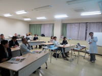 医療に関する講義を受ける学生たちが集まる教室の様子。講師が説明を行っている。