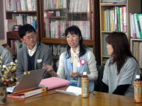 医療に関する会議で話し合う男女のグループ。背景には本が並ぶ書棚が見える。