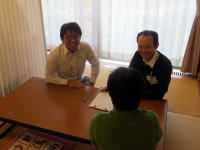 福島県立医科大学の教員と学生がテーブルを囲んで話し合っている様子。