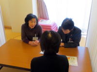 医療に関する相談を行っている3人の人物がテーブルを囲んでいる様子。
