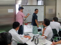 医療に関する研修を受ける参加者たちが、ホワイトボードを使って議論している様子。