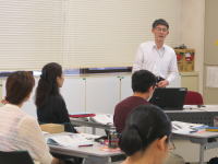 医療に関する講義を行う講師と、受講生たちが真剣に聴講している様子。