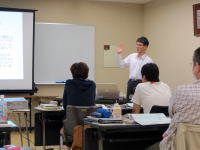 福島県立医科大学での講義中、スライドを指し示す講師と受講者たちの様子。