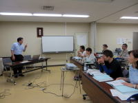 医療に関する講義を受ける学生たちと講師がいる教室の様子。