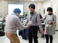 医療研修の一環として、参加者が実技を行っている様子。背景にはプレゼンテーション用のスクリーンが見える。