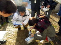 福島県立医科大学の学生たちが、屋外で実験器具を使って調査を行っている様子。