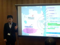 福島災害医療セミナーで講演する男性と、背景に表示された地図や情報。