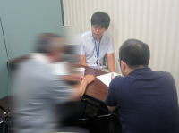 健康相談を受ける人々がテーブルを囲んで話し合っている様子。福島県立医科大学の相談室での一コマ。