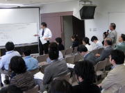 第44回医学教育セミナーで講演を行う講師と参加者たちが座っている様子。