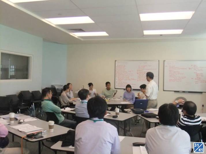 医療に関する講義を受ける参加者たちが集まる会議室の様子。講師がホワイトボードを使って説明している。