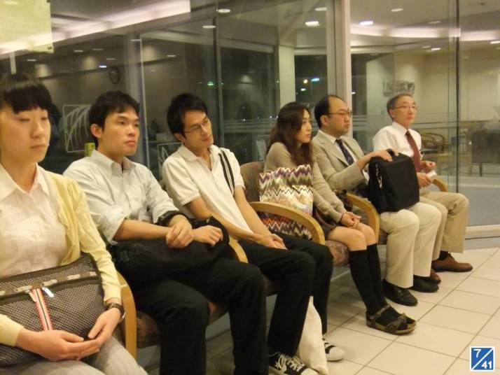 病院見学中の学生たちが待合室で座っている様子。