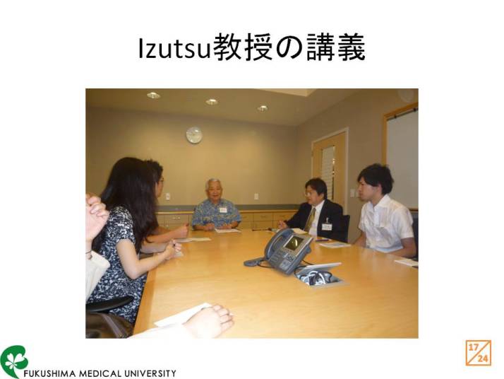 Izutsu教授が講義を行っている様子。学生たちが参加し、テーブルを囲んでいる。