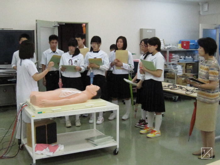 学校見学中の郡山第一中学校の生徒たちが、医療実習の説明を受けている様子。