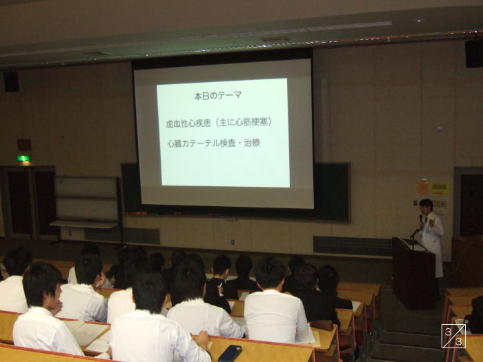 学校の教室でプレゼンテーションを行う講師と、聴講する学生たちの様子。テーマは「自信の形成」と「心のケア」。