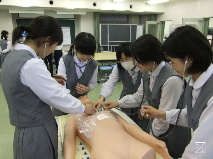 医療実習中の郡山第二中学校の3年生が、シミュレーターに聴診器を当てている様子。