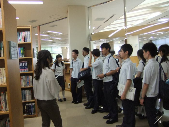 福島成蹊中学校の3年生が図書館で学校見学を受けている様子。教師が生徒に説明している。
