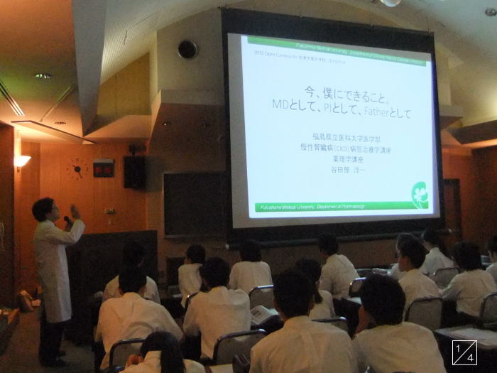 学校見学中の会津学鳳中学校の生徒たちが、講義を受ける様子。講師がスライドを使って説明している。