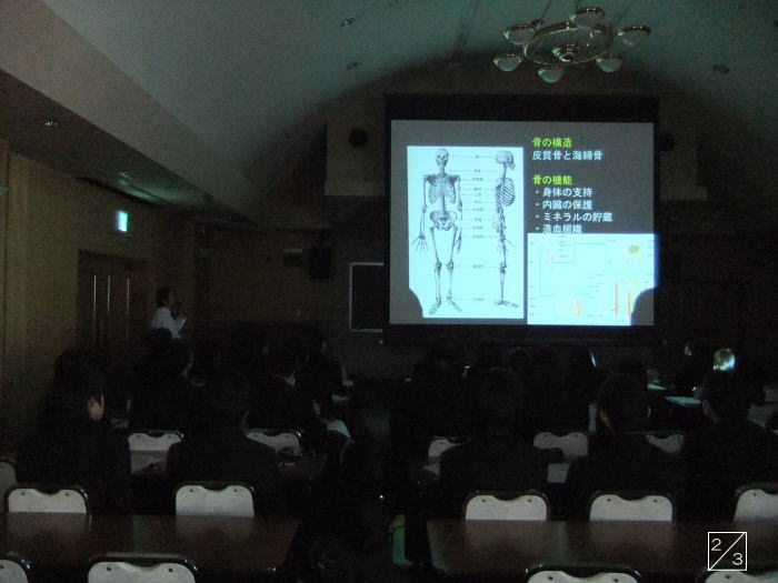 学校の教室で行われている福島県立磐城高等学校の見学中、講師がスライドを使って解剖学について説明している様子。