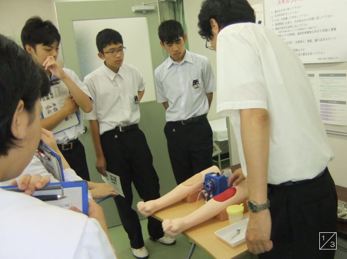 医療技術の実習を受ける郡山第一中学校の3年生たちが、講師の説明を聞いている様子。