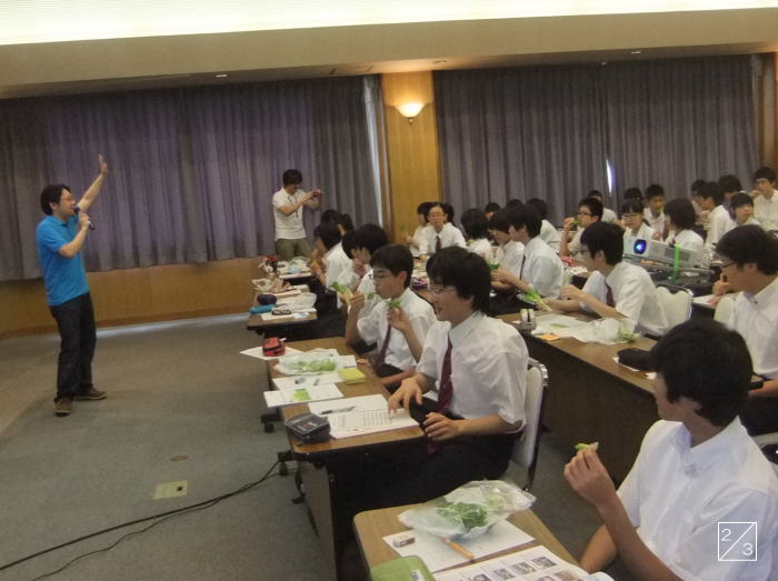 学校見学中の会津学鳳中学校の3年生が、講師の話を聞きながら資料を手にしている様子。