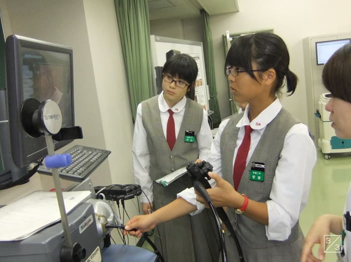学校見学中の安積第二中学校の3年生が医療機器を操作している様子。