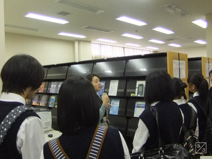 福島県立光南高等学校の図書室で、教員が生徒に資料を説明している様子。