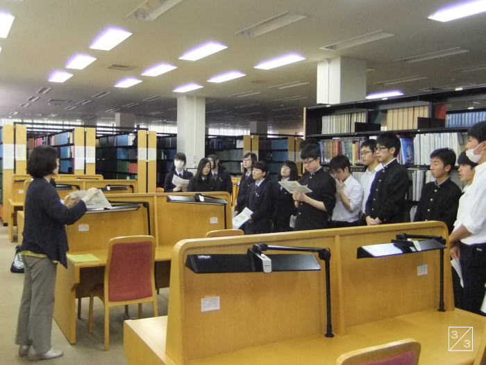 福島県立磐城高等学校の図書館で、教員が生徒に資料を説明している様子。