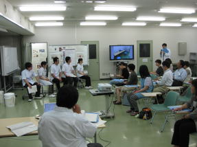 医療面接トレーニングの様子を示す教室内の風景。学生たちが講義を受け、発表を行っている。