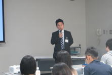 心エコーセミナーで講演を行う男性が、聴衆に向けて話している様子。