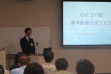 心エコーセミナーで講演を行う講師と参加者の様子。スライドには「心エコー図 基本的な流れ」と表示されている。