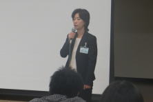 心エコーセミナーで講演を行う女性がマイクを持って話している様子。