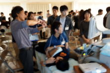 心エコーセミナーでの実習風景。参加者がエコー装置を使い、指導者からの説明を受けている様子。