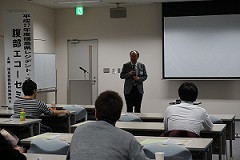 腹部エコーセミナーで講演する講師と参加者が座る教室の様子。