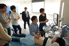 腹部エコーセミナーでの実習風景。受講者がエコー機器を使って腹部の検査を行っている様子。