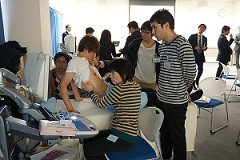 腹部エコーセミナーでの実習風景。学生が患者にエコー検査を行っている様子。
