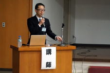 心エコーセミナーで講演を行う講師が、マイクを持って話している様子。