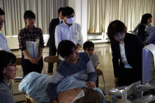 心エコーセミナーでの実習風景。受講者が患者に対してエコー検査を行い、指導者がアドバイスをしている様子。