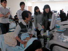 腹部エコーセミナーでの実習風景。学生がエコー機器を使い、指導者からの説明を受けている様子。