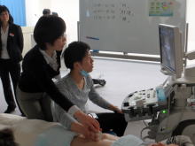 腹部エコーセミナーでエコー機器を操作する参加者と指導者の様子。