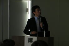 心エコーセミナーで講演を行う男性が、聴衆に向けて話している様子。