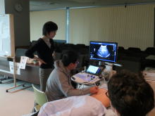 腹部エコーセミナーでの実習風景。医学生が超音波検査機器を操作し、講師が指導している様子。