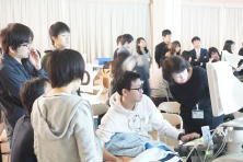 心エコーセミナーで学ぶ学生たちが、パソコンの画面を見ながら熱心に議論している様子。