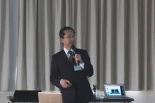 心エコーセミナーで講演を行う男性が、プレゼンテーションを行っている様子。背景にはカーテンとプロジェクターが見える。